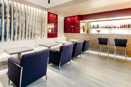 a restaurant with tables and chairs and a bar at Hotel Lajadira & Spa in Cortina dʼAmpezzo