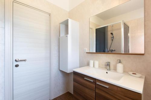 ein Bad mit einem Waschbecken und einem Spiegel in der Unterkunft Apartments Otia Seaview in Porat