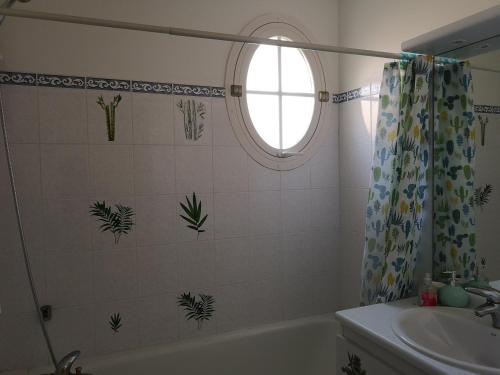 une salle de bain avec une baignoire, un lavabo et une fenêtre dans l'établissement Clés Vancances Europe, à Bussy-Saint-Georges