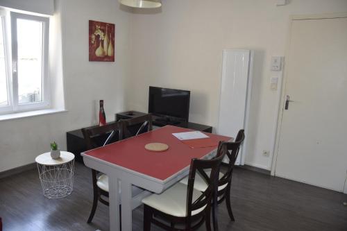 a dining room with a red table and chairs at Appart-alma in Saint-Laurent-sur-Sèvre