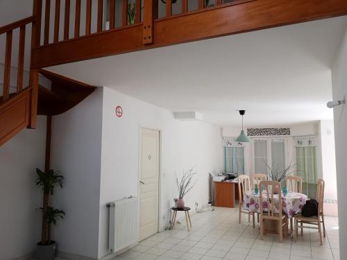 un salon avec une table et des chaises et un escalier dans l'établissement Clés Vancances Europe, à Bussy-Saint-Georges