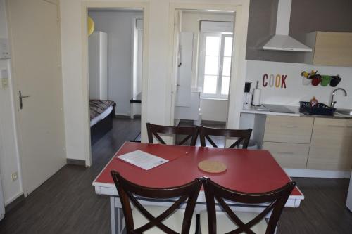 a kitchen and dining room with a red table and chairs at Appart-alma in Saint-Laurent-sur-Sèvre