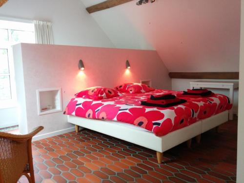 a bedroom with a red and white bed with red pillows at B&B Sint Blasius Hof in Zwalm