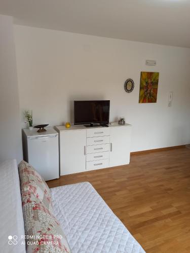 uma sala de estar com um sofá e uma televisão na parede em Apartman Marijana em Ljubuski