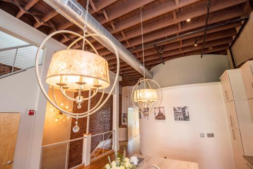 ノックスビルにあるLargest Rooftop w Firepit - Vaulted LUXE Penthouseの天井から2つの大きなシャンデリアがぶら下がっている部屋