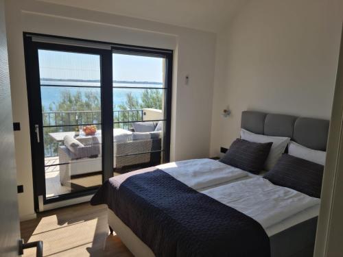 沃希Appartments Akrapovic的一间带大床的卧室和一个阳台