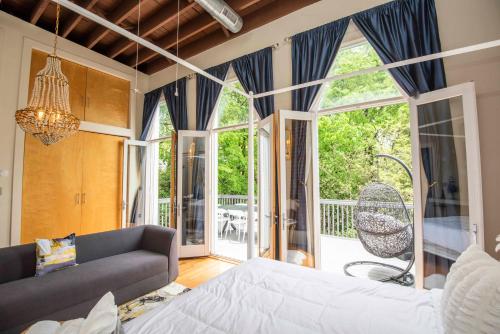 ノックスビルにあるLargest Rooftop w Firepit - Vaulted LUXE Penthouseのソファと大きな窓のあるリビングルーム