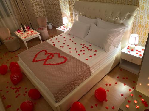 a bedroom with a bed with red hearts on the floor at Hotel Arberia in Tirana