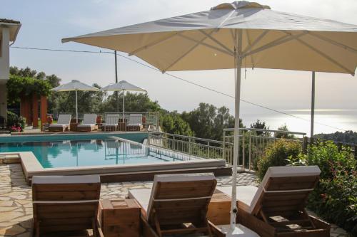 a pool with two chairs and an umbrella at Liogerma Apartments in Tsoukaladhes