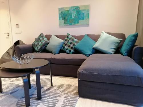 een woonkamer met een bruine bank en blauwe kussens bij Blue Diamond Ayla - Restricted to Family stays in Aqaba