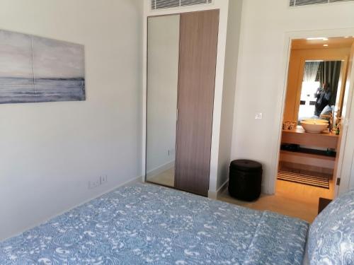 een slaapkamer met een bed, een kast en een spiegel bij Blue Diamond Ayla - Restricted to Family stays in Aqaba