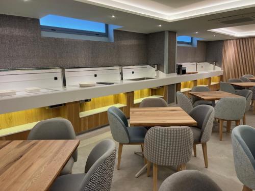 a dining room with tables and chairs and a counter at Hotel Noy in Almuñécar