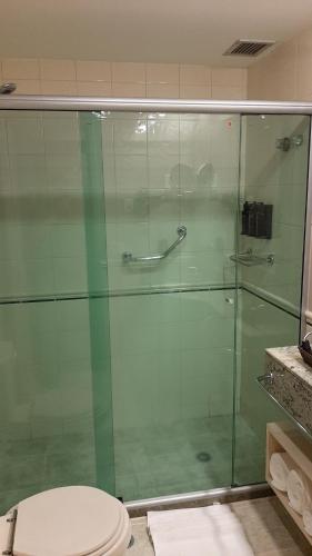 a bathroom with a glass shower with a toilet at A1 Flats WYM Brooklin in São Paulo