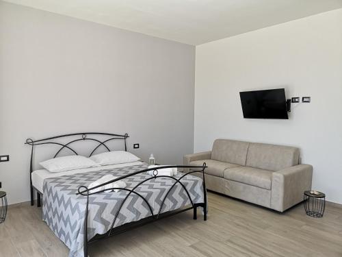 - une chambre avec un lit et un canapé dans l'établissement B&b tra scirocco e tramontana, à Gallipoli