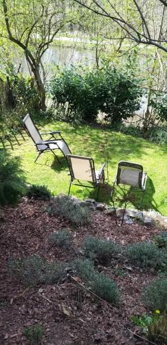 two chairs sitting in the grass in a yard at La Vallée in Seneffe