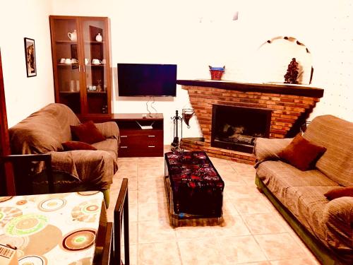 sala de estar con 2 sofás y chimenea en Casa en Busquistar, en Busquístar