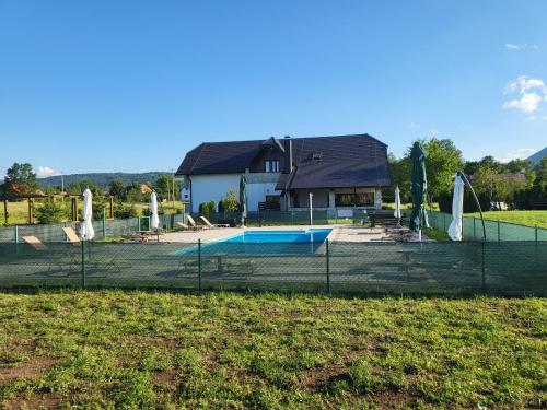 a fence in front of a house with a pool at Villa Stone in Rakovica