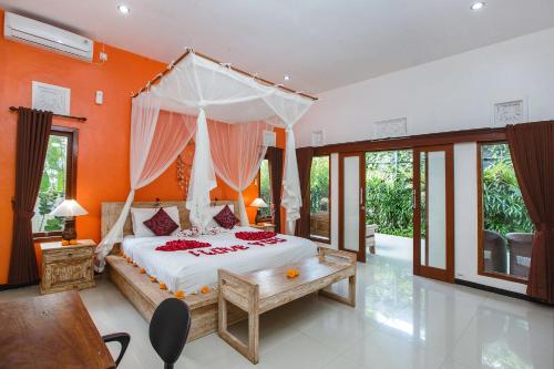 um quarto com uma grande cama branca com almofadas vermelhas em Tamyang Ubud Villas em Ubud