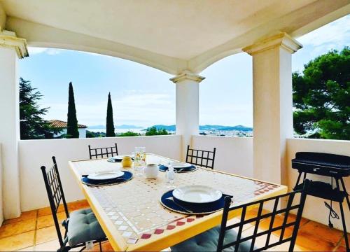 une table et des chaises sur un porche avec vue dans l'établissement Casa Joe Côté Mer, à La Seyne-sur-Mer