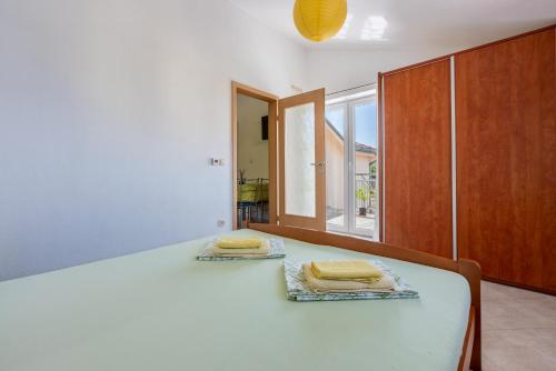 a bedroom with a bed with two towels on it at Apartmani Jarić in Novi Vinodolski