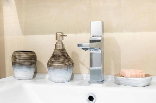 - un lavabo avec un robinet et 2 vases dans l'établissement Bärghäsli im BEO als Basis im Wintersportgebiet, à Gsteigwiler