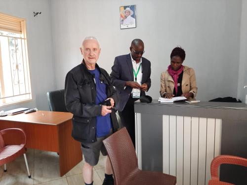 a group of people standing around a counter at Jusvero Motel in Jinja