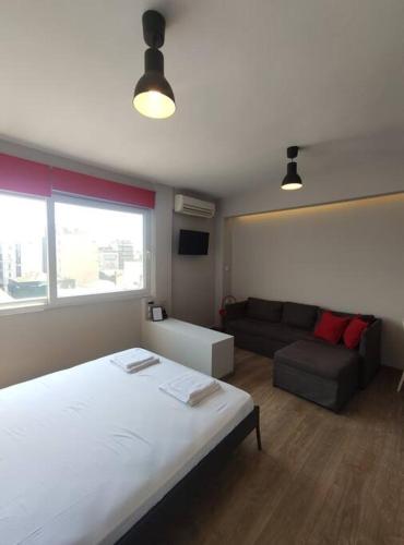 ein Schlafzimmer mit einem großen Bett und einem Sofa in der Unterkunft Antelope Studio 1 in Thessaloniki
