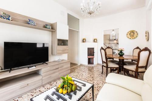 a living room with a television and a table at Ville Colonia Marina in Noto Marina