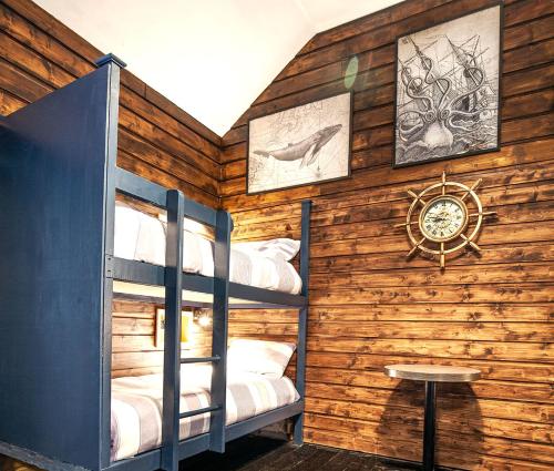 a room with two bunk beds and a clock on a wall at The Valley House Hostel & Bar in Achill