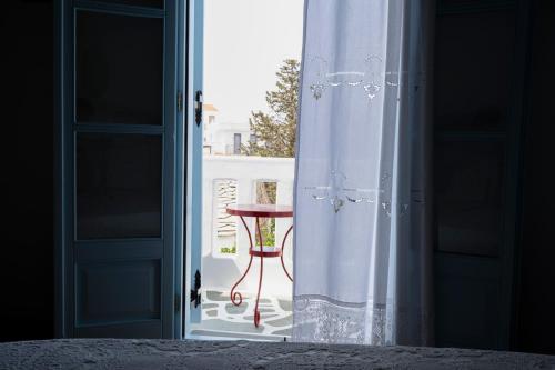 an open door to a balcony with a table outside at Stella's traditional house. in Alonnisos Old Town