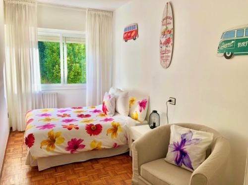 a bedroom with a bed and a chair at Apartamento con vistas al mar en Primera Línea. in Muros