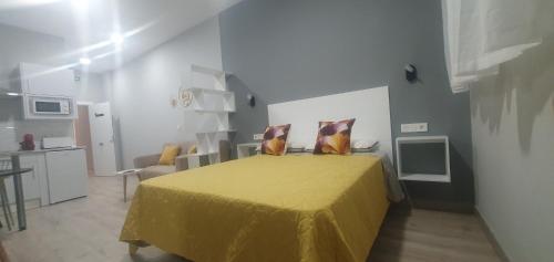 a bedroom with a bed with a yellow bedspread at Apartamentos Las trece llaves Jacuzzi bajo reserva in Merida