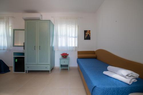 un soggiorno con divano blu e armadio di Albergo Villa A Mare a Peschici