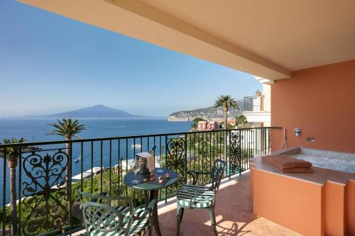 a balcony with a table and chairs and the ocean at Grand Hotel Royal in Sorrento