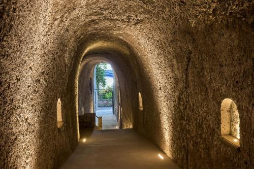 a tunnel in a stone wall with lights at Grand Hotel Royal in Sorrento
