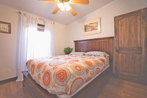 ein Schlafzimmer mit einem Bett mit einer Bettdecke und einem Fenster in der Unterkunft Sunny Southwest Cottage in Mancos
