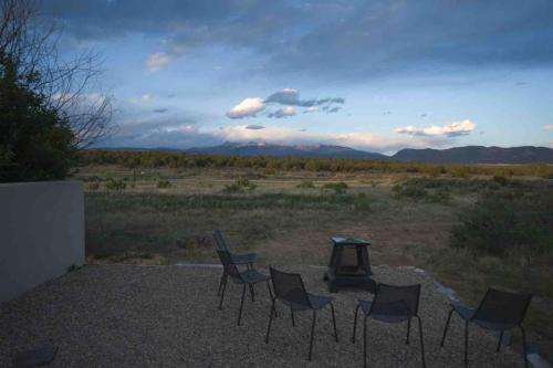 eine Gruppe von Stühlen und einem Tisch auf einem Feld in der Unterkunft Sunny Southwest Cottage in Mancos