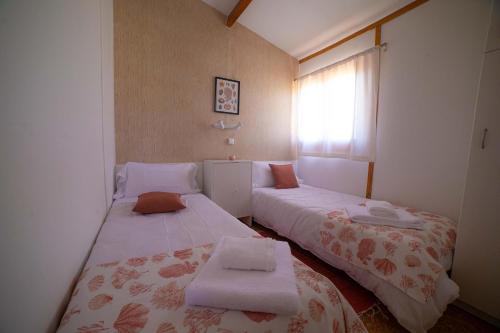 a small room with two beds and a window at Las Casitas de Guadamur in Guadamur