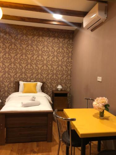 a bedroom with a bed and a yellow table at Borjomi Yellow Hotel in Borjomi