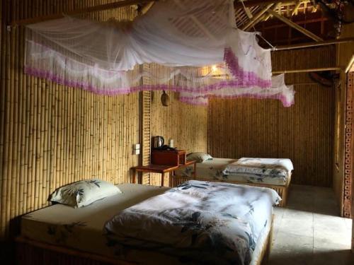 a bedroom with two beds and a mosquito net at Ninh Binh Valley Homestay in Ninh Binh