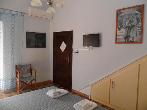 a bedroom with a bed and a tv on the wall at Sa Domo de Minnanna in Castelsardo