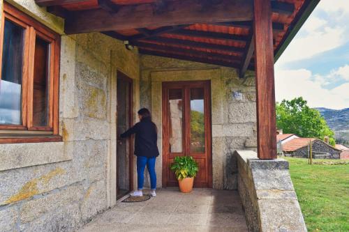 a person is standing outside of a building at Casa Florestal, na Branda da Bouça dos Homens in Gavieira