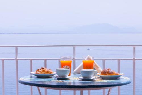 a table with two plates of food and two glasses of orange juice at Villa Paradise (Amalfi Coast - Luxury Home - Beach) in Vietri sul Mare