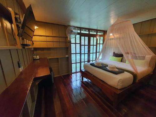 a bedroom with a bed with a mosquito net at Malulee KhaoSok Resort in Khao Sok