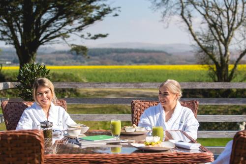 two women sitting at a table in front of a field at Boringdon Hall Hotel and Spa in Plymouth