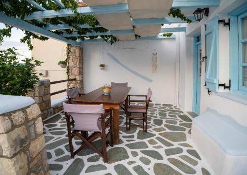 a patio with a wooden table and chairs at Stella's traditional house. in Alonnisos Old Town