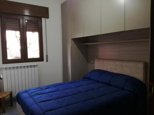 een slaapkamer met een blauw bed en een raam bij Da Lisa in Desulo