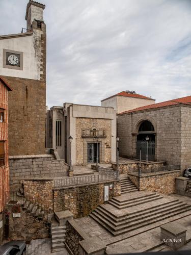 an old brick building with stairs and a clock tower at Auténtica buhardilla en el centro de Béjar in Béjar