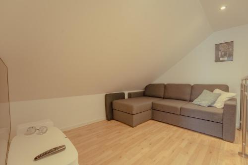 a living room with a couch in the attic at Á Snætu - Serene Village Stay Surrounded by Nature in Sandavágur
