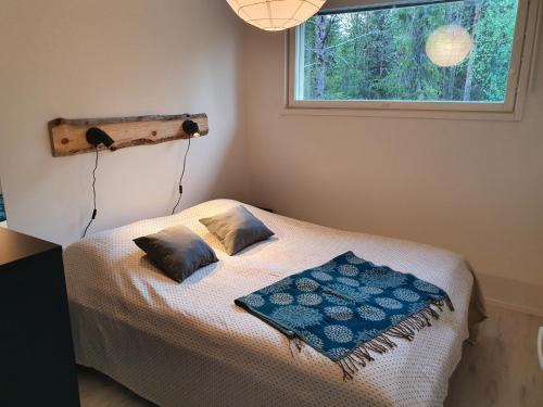 een slaapkamer met een bed met 2 kussens en een raam bij Ylläs Terhakka - Uusi huvila kuudelle in Äkäslompolo